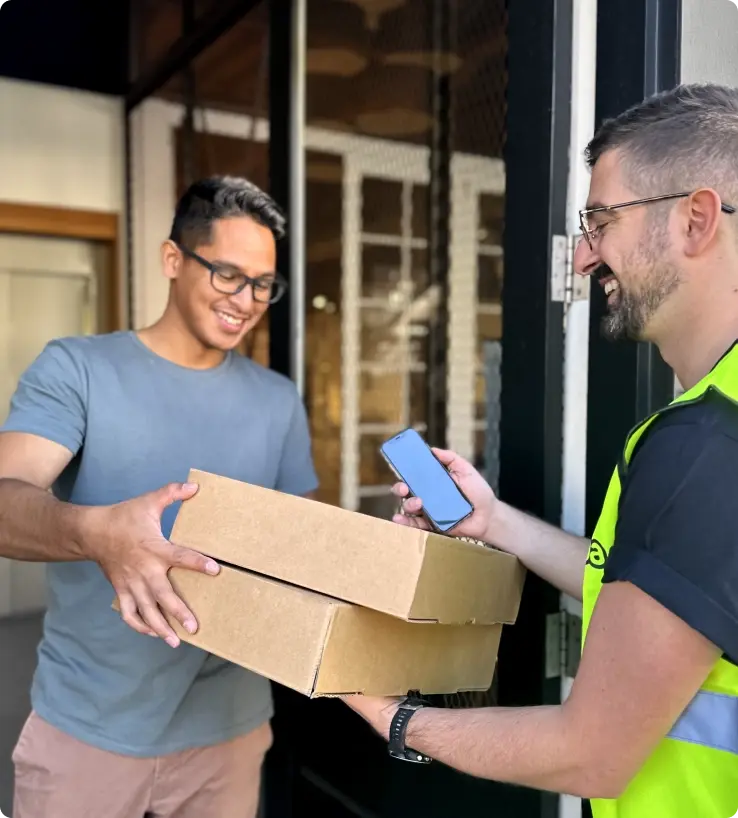 Image of a Sherpa Driver collecting a package from a client with their Sherpa Delivery mobile app